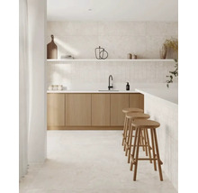Moderne Küche mit hellen Holzschränken, weißen Arbeitsplatten, schwarzer Armatur, Wandfliesen in Steinoptik und drei hölzernen Barhockern.