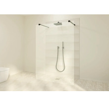 Douche à l'italienne avec paroi en verre, barres de stabilisation noires, pommeau de pluie et douchette dans une salle de bain moderne.