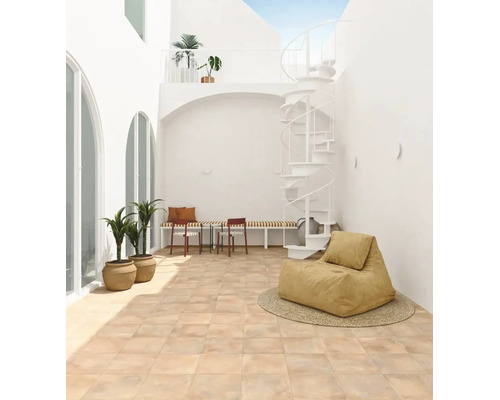 Helle Terrasse mit quadratischen Bodenfliesen in Terrakotta-Optik, einer weißen Wendeltreppe, Topfpflanzen und modernen Sitzmöbeln.