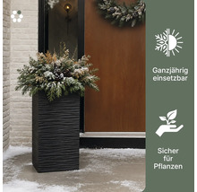 elho Logo. Hoher Pflanzkübel mit Wellenstruktur und winterlicher Bepflanzung vor einem Hauseingang im Schnee. Ganzjährig nutzbar und sicher für Pflanzen.