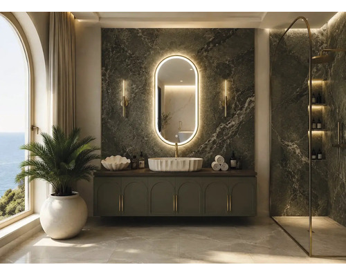 Luxuriöses Badezimmer mit dunkelgrüner Marmorwand, ovalem LED-Spiegel, grünem Waschtisch, weißem Aufsatzwaschbecken und Walk-In Dusche.