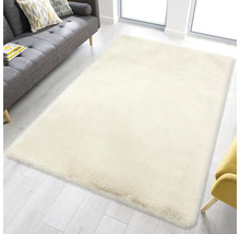 Weicher, rechteckiger Hochflor-Teppich in einem hellen Wohnzimmer mit grauem Sofa und hellem Holzboden.