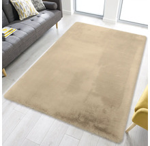 Rechteckiger, flauschiger Teppich in einem hellen Wohnzimmer mit grauem Sofa und hellem Holzboden.