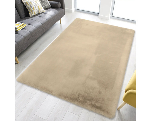 Rechteckiger, flauschiger Teppich in einem hellen Wohnzimmer mit grauem Sofa und hellem Holzboden.