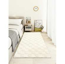 Weißer Teppich Läufer mit quadratischem Reliefmuster in einem hellen, modern eingerichteten Schlafzimmer auf hellem Holzboden.