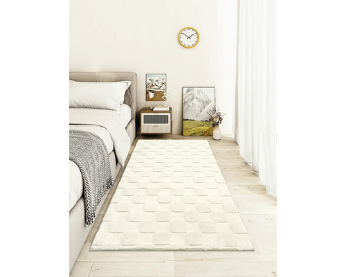 Weißer Teppich Läufer mit quadratischem Reliefmuster in einem hellen, modern eingerichteten Schlafzimmer auf hellem Holzboden.