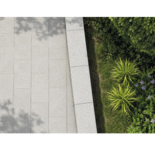 Terrassenplatten und Mauersteine aus Granit im Aussenbereich mit Bepflanzung.