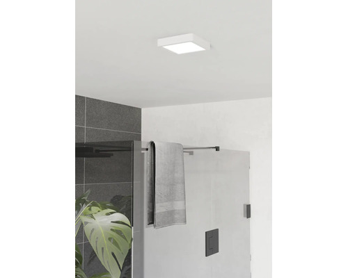 Quadratische LED-Deckenleuchte im modernen Badezimmer über einer Glasdusche mit schwarzen Beschlägen und dunkelgrauen Wandfliesen.