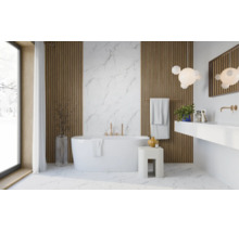 Salle de bain moderne avec baignoire en îlot, panneaux muraux en bois, mur effet marbre et robinetterie dorée.