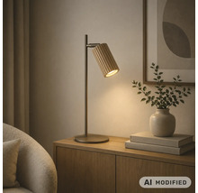 Lampe de table moderne avec abat-jour nervuré sur un meuble en bois à côté d'un vase et de livres.