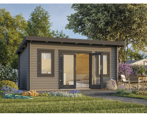 Abri de jardin moderne en bois avec toit en pente, double porte vitrée et fenêtres dans un jardin planté avec coin salon.
