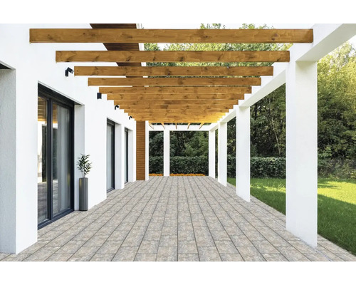 Terrasse moderne avec des pavés, une pergola en bois à poutres horizontales et des colonnes blanches à côté d'un jardin.