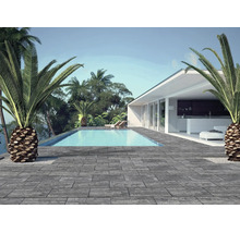 Terrasse moderne avec des dalles de sol aspect pierre, une piscine et une maison blanche entourée de palmiers.