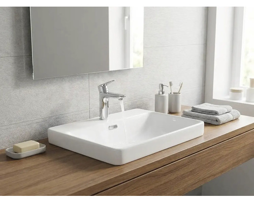 Modernes Badezimmer mit weißem Aufsatzwaschbecken aus Keramik auf einer Holzplatte, verchromter Waschtischarmatur und einem Spiegel.