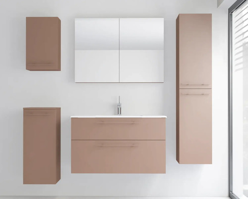 Ensemble de meubles de salle de bains moderne en vieux rose mat avec sous-vasque, lavabo blanc, armoire de toilette et colonnes latérales.