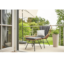 Moderner Balkon mit Lounge-Sessel aus Geflecht, Hocker, grauen Kissen, Sonnenschirm, Beistelltisch und Pflanzgefäß mit Blick in den Garten.