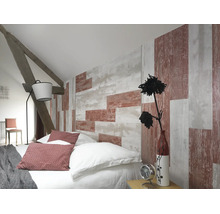 Schlafzimmer unter Dachschräge mit Tapete in Holzoptik, Bett mit Kissen, Stehlampe und sichtbaren Holzbalken.