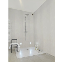 Helles, modernes Badezimmer mit begehbarer Dusche, Regenduschkopf, Handbrause, hellen Wandfliesen und einem Stuhl mit weißem Handtuch.