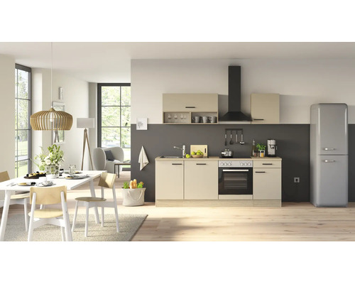 Cuisine moderne avec façades beiges, cuisinière électrique intégrée, hotte aspirante et réfrigérateur rétro autonome dans un espace ouvert.