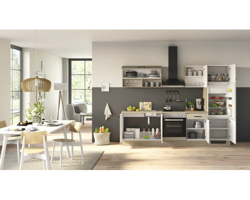 Cuisine équipée moderne dans un espace de vie lumineux et ouvert avec appareils électroménagers intégrés et coin repas.