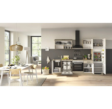 Cuisine moderne équipée dans un espace de vie lumineux avec électroménager, évier et coin repas avec table en bois et chaises.