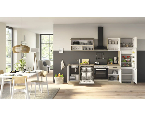 Cuisine moderne équipée dans un espace de vie lumineux avec électroménager, évier et coin repas avec table en bois et chaises.