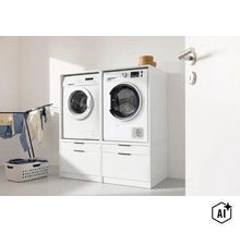 Deux armoires de lavage blanches côte à côte avec tiroirs en bas, lave-linge et sèche-linge surélevés dans une buanderie. (Image AI modified or generated)