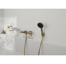 Wannenarmatur mit Handbrause in moderner Gestaltung an einer hellen Badezimmerwand mit Ablageregal