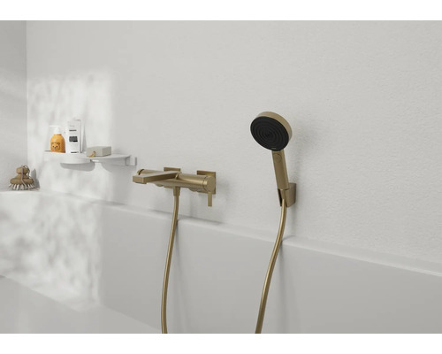 Wannenarmatur mit Handbrause in moderner Gestaltung an einer hellen Badezimmerwand mit Ablageregal