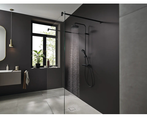 Modernes Badezimmer mit ebenerdiger Walk In Dusche, schwarzem Duschsystem mit Regendusche und Handbrause sowie Glasduschwand in elegantem Design.