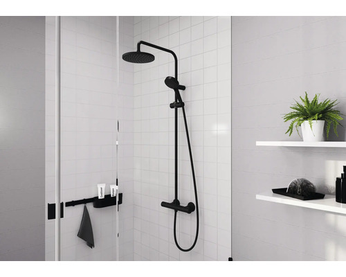 Modernes Duschsystem mit Regendusche und Handbrause in mattschwarzer Ausführung montiert in einer hellen gefliesten Duschkabine.