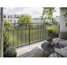 Balcon avec pare-vue en plastique structuré, garde-corps en métal, terrasse en bois et salon moderne avec des plantes.