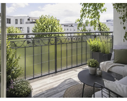 Balcon avec pare-vue en plastique structuré, garde-corps en métal, terrasse en bois et salon moderne avec des plantes.