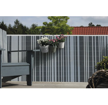 Brise vue de balcon en lamelles plastiques sur une rambarde avec des pots de fleurs suspendus et des meubles de jardin.