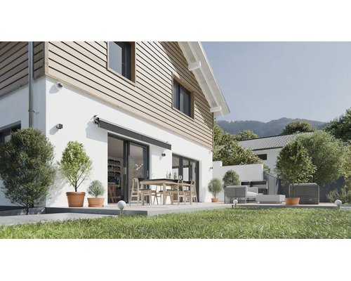 Geschlossene Kassettenmarkise in Anthrazit, montiert an einer weissen Hauswand über einer Terrassentür, mit modernem Garten und Terrassenmöbeln.