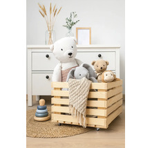 Caisse en bois sur roulettes remplie de peluches dans une chambre d'enfant organisée avec commode.
