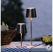 Zwei moderne LED Akkuleuchten in Metalloptik als Tischlampen für den Außenbereich auf einem gedeckten Tisch. (Image AI modified or generated)