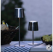 Zwei moderne, schlanke LED Tischleuchten aus Metall auf einem gedeckten Tisch im Freien. (Image AI modified or generated)