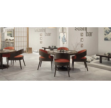 Intérieur de restaurant de sushi moderne avec tables rondes, chaises courbes et sol carrelé dans un design d'inspiration japonaise.
