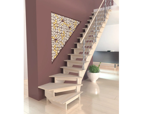 Escalier moderne en bois avec garde-corps métallique près d'un mur décoré de galets triangulaires dans un espace de vie ouvert.