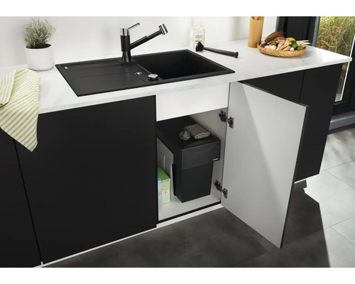 Cuisine moderne avec évier encastré, mitigeur et système de tri des déchets intégré dans le meuble bas ouvert.