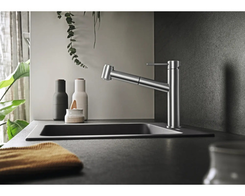 Moderne Küchenarmatur mit ausziehbarer Brause in einer eleganten Küchenumgebung mit Spülbecken und Dekorationselementen.