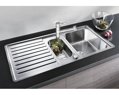 Évier encastrable en acier inoxydable avec égouttoir, cuve principale et petit bac, incluant un mitigeur de cuisine moderne.