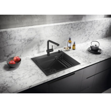 Moderne Küchenspüle mit Einhebelmischarmatur auf einer Arbeitsplatte in Marmoroptik mit Granitbecken und integriertem Abtropfgitter.