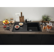 Évier encastrable moderne noir avec égouttoir et robinetterie assortie dans une cuisine avec plan de travail aspect bois et façades foncées.