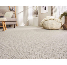 Wohnzimmer mit flächendeckendem Teppichboden in strukturierter Optik, helles Interieur mit Sofa und Sitzhocker für ein gemütliches Ambiente.