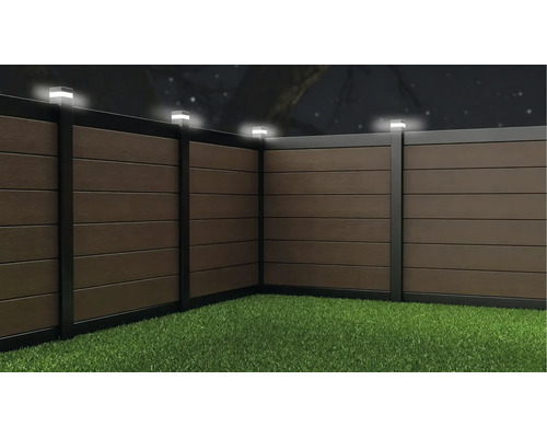 Clôture de jardin en bois composite avec éclairage LED intégré sur les poteaux, vue de nuit.