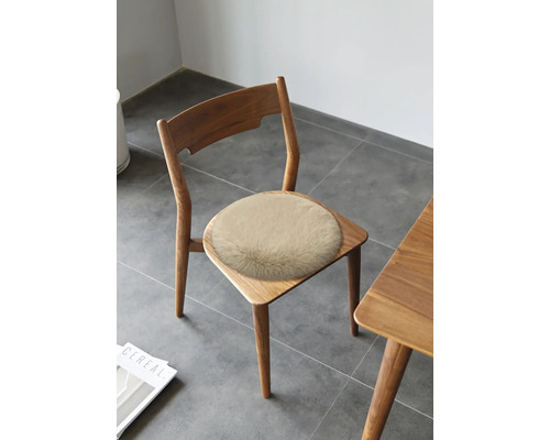 Coussin d'assise rond en fausse fourrure sur une chaise en bois