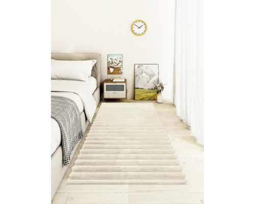 Ein weicher Hochflor Bettvorleger im modernen Schlafzimmer mit hellem Holzboden und strukturierten Streifen.
