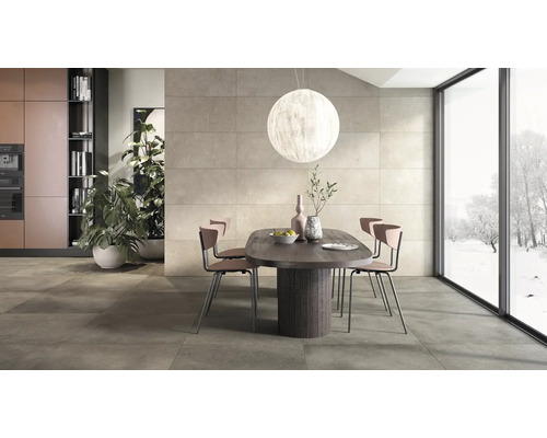 Salle à manger moderne avec grands carreaux de sol et muraux aspect béton, table en bois ovale et baies vitrées avec vue sur l extérieur.